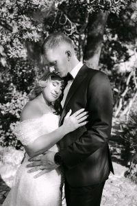 Vjenčani par u zagrljaju pod stablom, romantična fotografija.