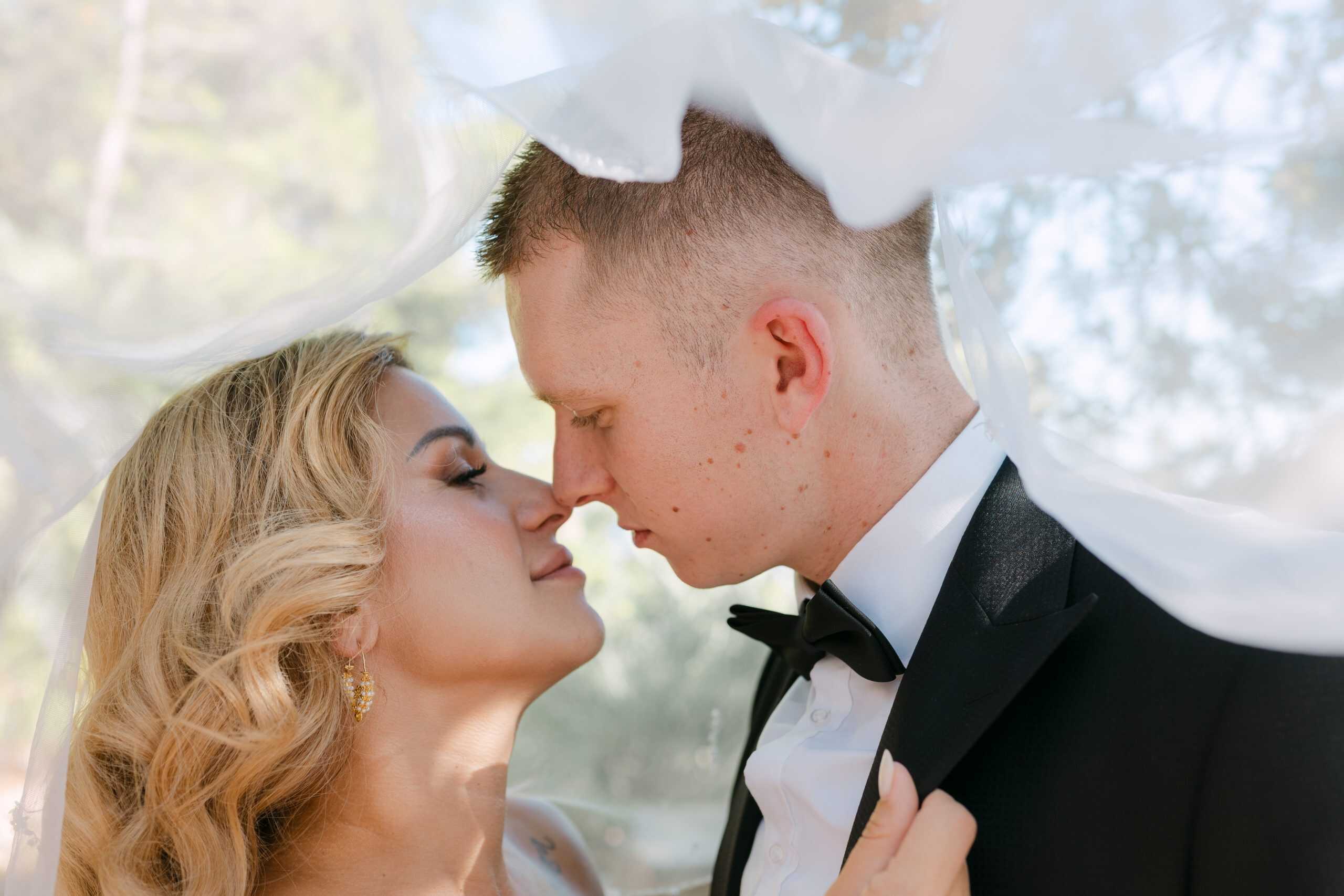 Mladenci se nježno dodiruju nosevima ispod prozirnog vela. Intimni i emotivni krupni kadar s destination vjenčanog sessiona u Dubrovniku.