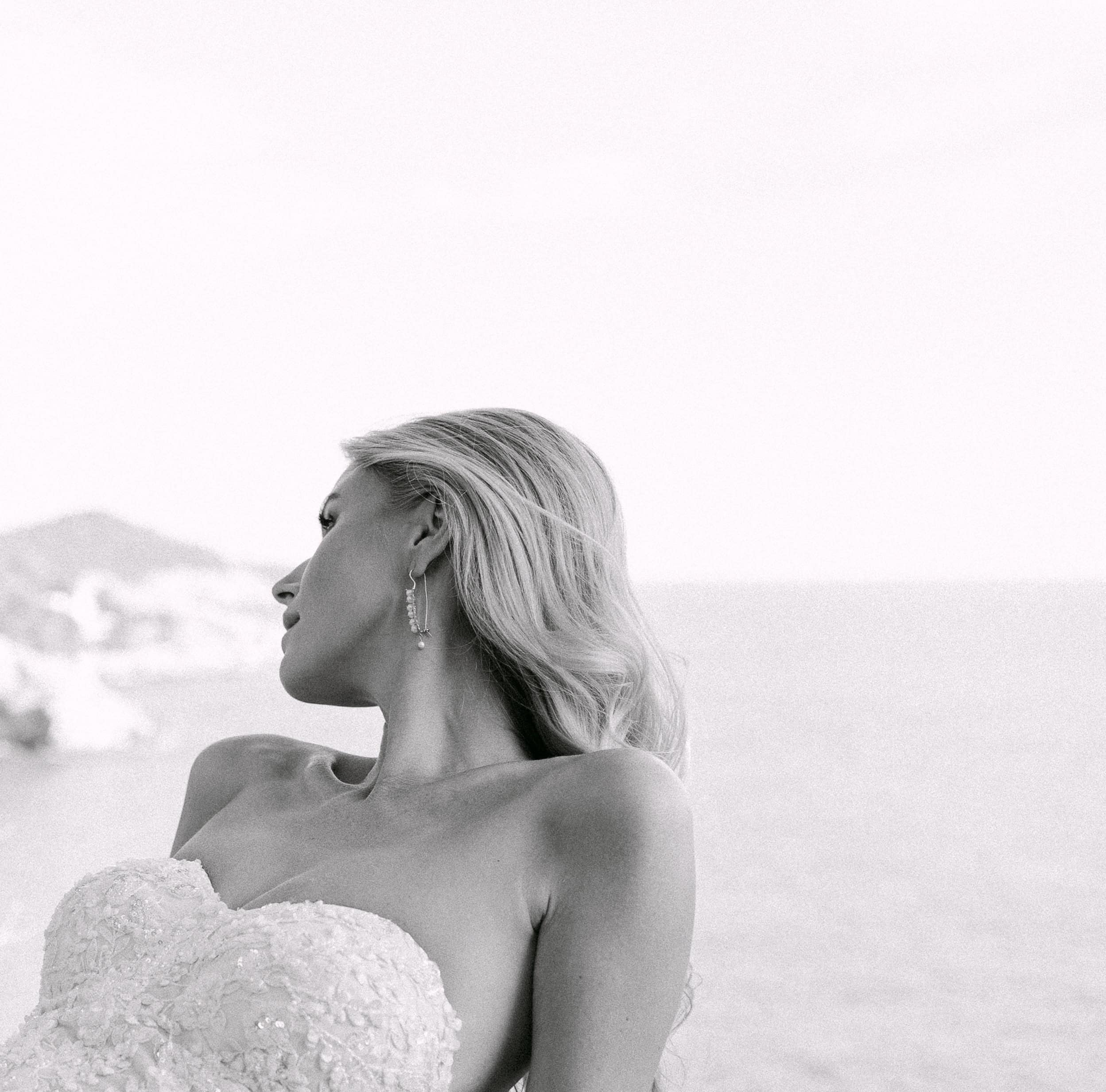 Krupni crno-bijeli editorial portret mladenke s naglaskom na elegantne naušnice i teksturu vjenčanice. Destination wedding session inspiracija.